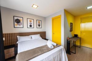 1 dormitorio con cama y puerta amarilla en MV17 - Studio Próximo à Estação Brás: Conforto Garantido!, en São Paulo