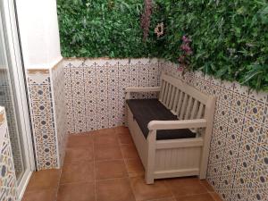 a garden bench on a tiled wall with plants at My Granada Garden - Apartamento Orquídea in Granada