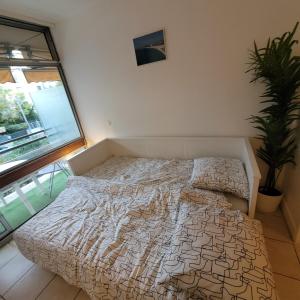 a bed in a bedroom with a large window at 06U - Beau studio en résidence avec piscine et tennis in Saint-Laurent-du-Var
