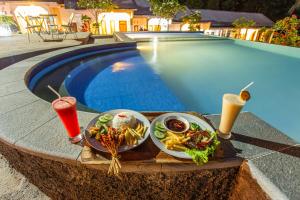 a tray of food on a table next to a swimming pool at Pondok Guru Bakti Cottage in Senaru