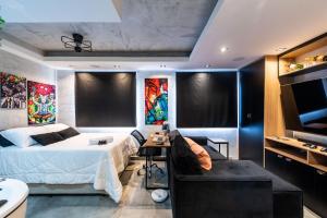 1 dormitorio con cama, sofá y TV en AA212 Studio aconchegante c/ vaga de garagem, en São Paulo