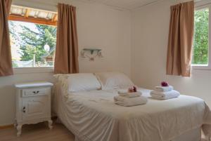 a bedroom with a bed with towels on it at Cabaña Le Betulle in San Martín de los Andes