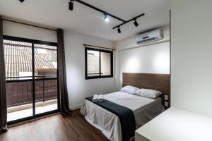 1 dormitorio con cama y ventana grande en MA21 - Aconchego Próximo à Estação da Luz: Seu Refúgio na Cidade, en São Paulo