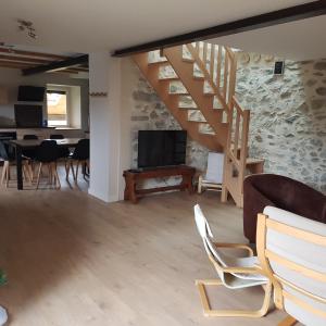 a living room with a staircase and a table and chairs at Appartement entre lac et montagnes in Saint-Paul-en-Chablais