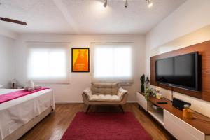 1 dormitorio con TV de pantalla plana grande y 1 cama en BR304 Studio aconchegante no Frei Caneca, en São Paulo