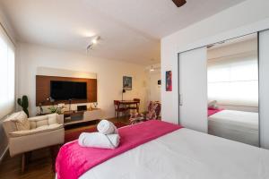 1 dormitorio con 1 cama grande con manta rosa en BR304 Studio aconchegante no Frei Caneca, en São Paulo