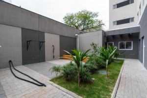 un edificio con una manguera junto a un patio con plantas en MV46A - Studio Próximo à Estação Brás: Conforto Garantido, en São Paulo
