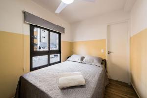 Un dormitorio con una cama grande y una ventana en MI511 - Studio Aconchegante para 4 Pessoas Próximo ao Parque Augusta, en São Paulo