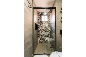 y baño con ducha y puerta de cristal. en MI511 - Studio Aconchegante para 4 Pessoas Próximo ao Parque Augusta, en São Paulo