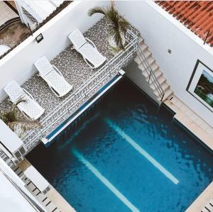 - une vue sur la piscine avec 2 chaises longues dans l'établissement Hotel Suite Royal, à Melgar