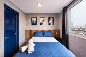 Un dormitorio con una cama azul y una ventana en MV53 - Studio Próximo à Estação Brás: Conforto Garantido, en São Paulo