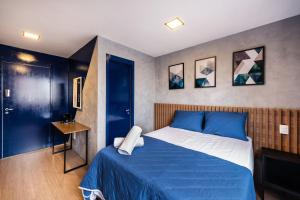 1 dormitorio con 1 cama con colcha azul en MV53 - Encanto nas Proximidades da Estação Brás: Seu Estúdio Acolhedor!, en São Paulo