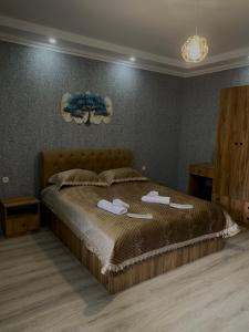 a bedroom with a bed with two towels on it at White House In Borjomi in Borjomi