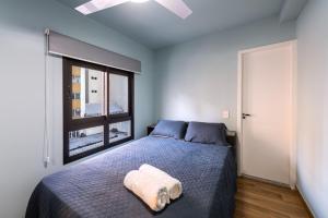 Un dormitorio con una cama azul y una ventana en MI611 - Studio Aconchegante para 4 Pessoas Próximo ao Parque Augusta, en São Paulo