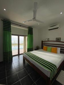 Reef Bungalow Hotel في Pamunugama: غرفة نوم بسرير كبير مع ستائر خضراء