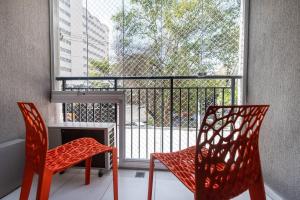 balcón con 2 sillas, mesa y ventana en HO1 - Apartamento 1 Dormitório na Vila Mariana, Moderno e Completo., en São Paulo