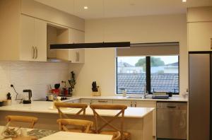 - une cuisine avec une table et deux chaises dans l'établissement Cozy and comfortable, sunny three-storey building, à Auckland