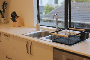 un comptoir de cuisine avec un évier et une fenêtre dans l'établissement Cozy and comfortable, sunny three-storey building, à Auckland