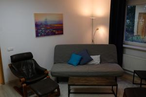 ein Wohnzimmer mit einem Sofa und einem Stuhl in der Unterkunft Ruhige Wohnung im Westen Hamburgs in Halstenbek