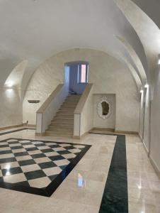Habitación con escalera y suelo de tablero de ajedrez en B&B Palazzo del Contestabile en Troia