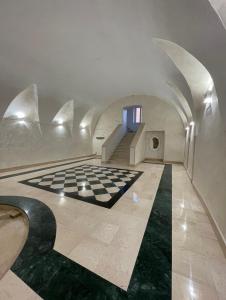 um quarto com piso em xadrez e uma escada em B&B Palazzo del Contestabile em Tróia