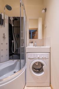 een badkamer met een wasmachine en een douche bij Seaside Escape in Dzintaru Studio Apartments 100m from Beach and Near Forest Park in Jūrmala
