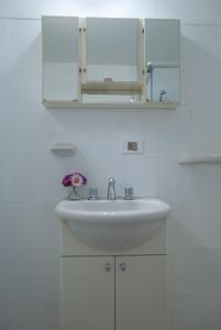 a white bathroom with a sink and a mirror at Cabaña Le Betulle in San Martín de los Andes