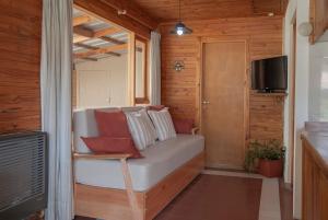 ein Wohnzimmer mit einem Sofa und einem TV in der Unterkunft Cabaña Le Betulle in San Martín de los Andes
