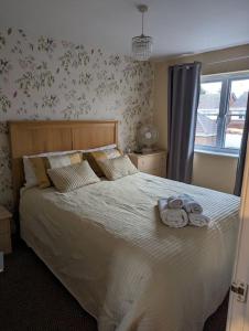 a bedroom with a large bed with towels on it at 3 bedroom detached by the sea in Prestatyn