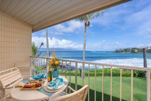 a table on a balcony with a view of the ocean at Napili Shores A202 OF Studio condo in Kahana