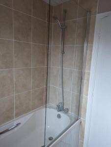 een douche met een glazen deur in de badkamer bij 3 bedroom detached by the sea in Prestatyn