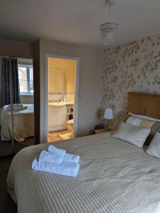 een slaapkamer met een bed met handdoeken erop bij 3 bedroom detached by the sea in Prestatyn