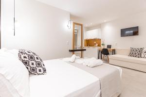 a white bedroom with a bed and a couch at Senso Deluxe in Limenaria