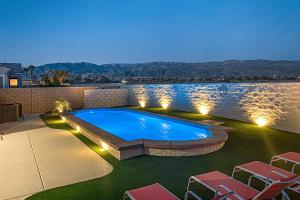 een zwembad in een achtertuin met stoelen en verlichting bij Sentiero Haven Permit# 50114 in Indio