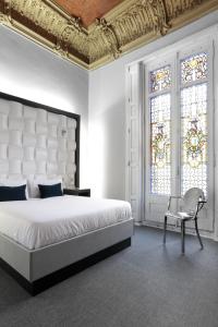 Amra Barcelona Gran Via في برشلونة: غرفة نوم بسرير وكرسي ونافذة