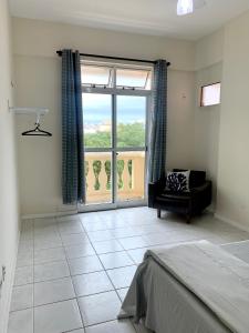 a living room with a large window and a couch at Apartamento à 2 minutos da Praia, na Prainha em Arraial do Cabo in Arraial do Cabo