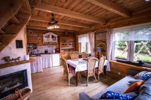 a kitchen and dining room with a table and a fireplace at LESZCZYNOWY STOK in Lutowiska