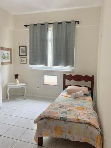 1 dormitorio con cama y ventana en Apartamento Segunda Quadra da Praia - Prainha - Arraial do Cabo, en Arraial do Cabo