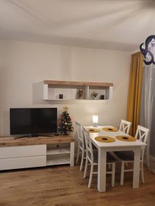 a living room with a table and a television and a christmas tree at APARTAMENT-SADOWA in Elblag