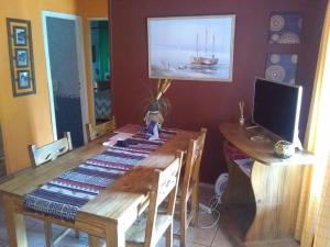 comedor con mesa de madera y monitor de ordenador en Piedra de luna en Villa Carlos Paz