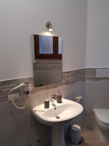 ein Badezimmer mit einem Waschbecken, einem WC und einem Spiegel in der Unterkunft Gulliver's Lodge in Rom