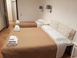 two beds in a hotel room with towels on them at Gulliver's Lodge in Rome