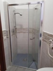 um chuveiro com uma porta de vidro na casa de banho em Gulliver's Lodge em Roma