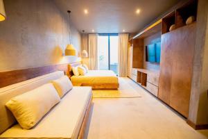 a hotel room with two beds and a television at Casa Malbec, Valle de Guadalupe in Valle de Guadalupe