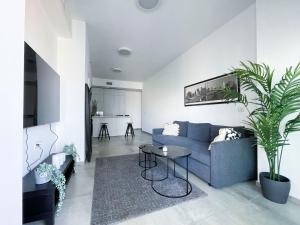 een woonkamer met een blauwe bank en een tafel bij Midtown Tel Aviv Luxury Apartment in Tel Aviv