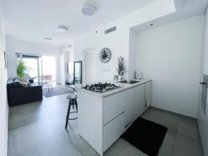 uma cozinha branca com uma placa de fogão num quarto em Midtown Tel Aviv Luxury Apartment em Tel Aviv