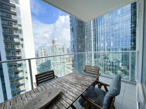 a table and chairs on a balcony with a view of a city at Midtown Tel Aviv Luxury Apartment in Tel Aviv