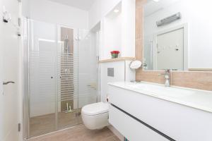 ein Badezimmer mit Toilette, Waschbecken und Dusche in der Unterkunft Carmel Boutique Apartments - Urban Forest in Haifa + 13 Fotos