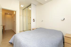 a white bedroom with a bed and a hallway at Carmel Boutique Apartments - Urban Forest in Haifa