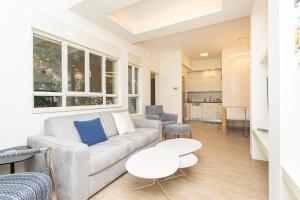 ein Wohnzimmer mit Sofa und Tisch in der Unterkunft Carmel Boutique Apartments - Urban Forest in Haifa